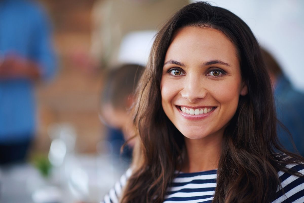 Woman with bright smile illustrating benefits of fluoride for all ages