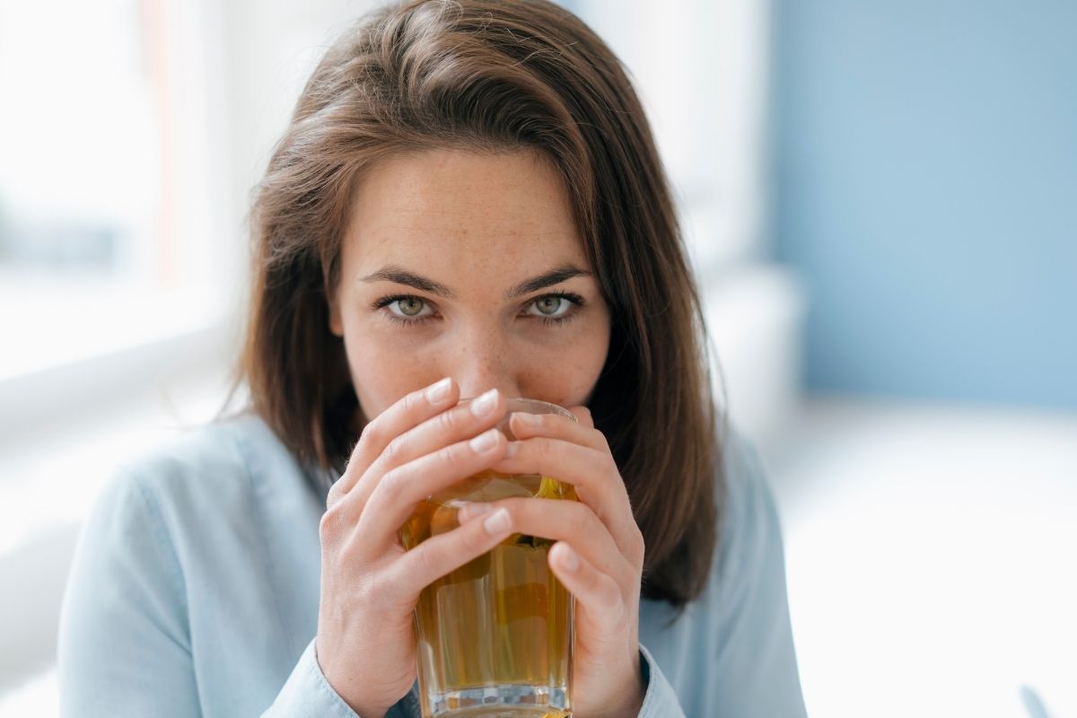 Women with glass filled with ACV water Women with glass filled with ACV water