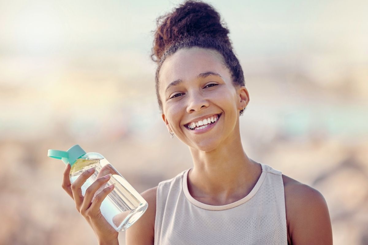 Young women smiling with water bottle in hand