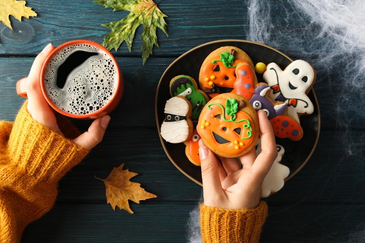 top view of a Person holding drink and halloween treats in hand
