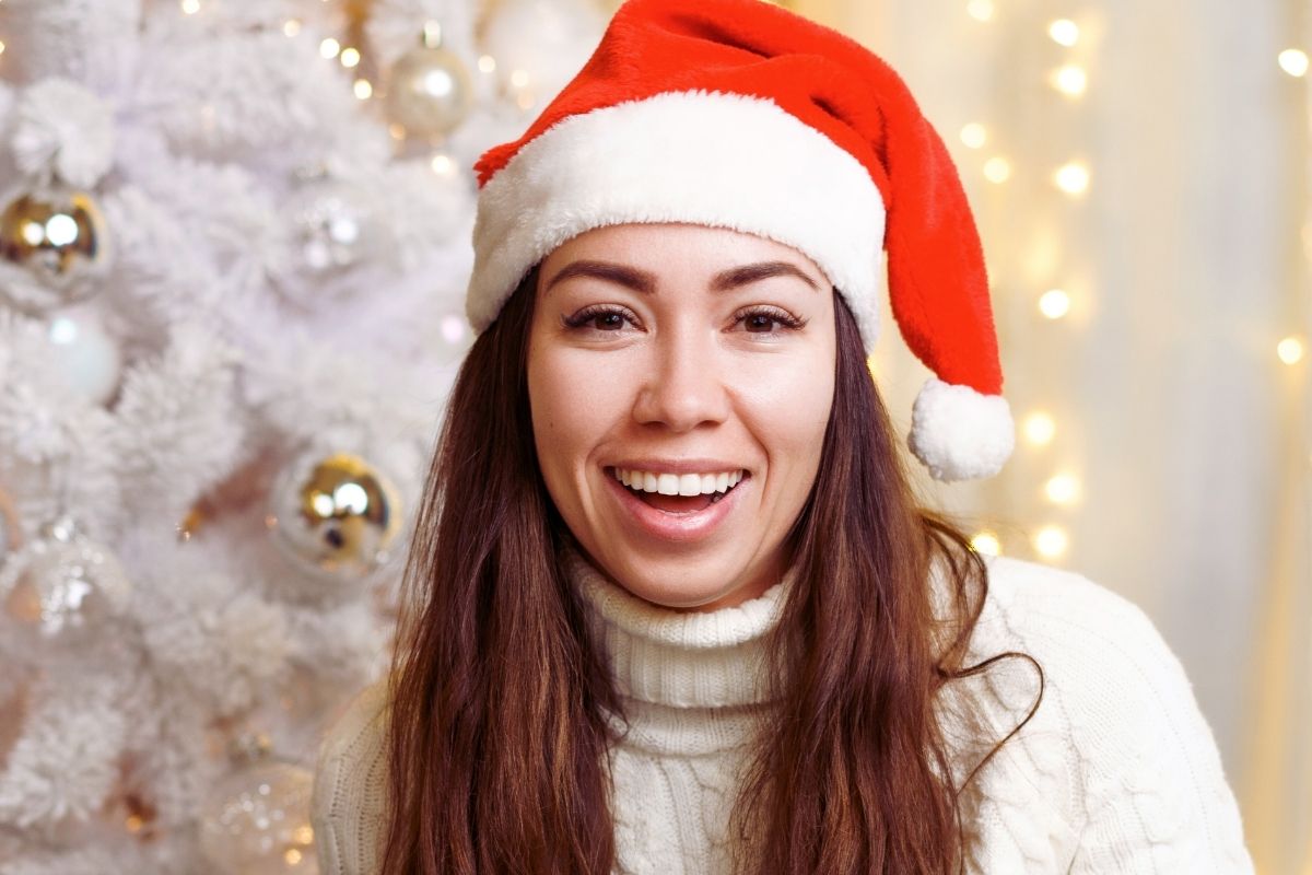 Women with santa cap smiling widely